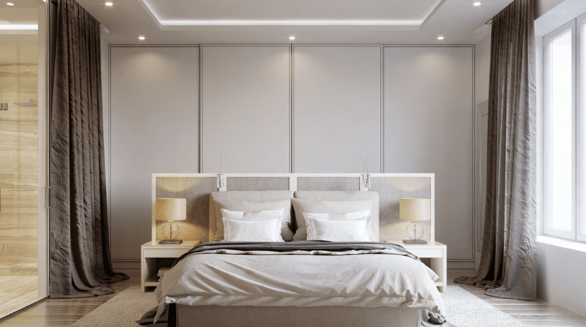 Chambre moderne comprenant un grand lit avec une literie grise, des tables de chevet doubles avec lampes et une tête de lit mur à mur contre une armoire à portes coulissantes, le tout rehaussé par des rideaux élégants et un éclairage tamisé à Binghatt.