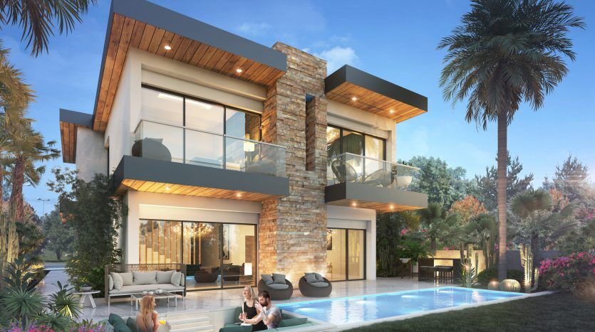 Une maison moderne à deux étages dans les lagons de Damac sur la Costa Brava avec de grandes fenêtres, un balcon et des accents en pierre, comprenant une piscine où deux femmes se détendent sur des chaises longues en discutant et un homme nageant