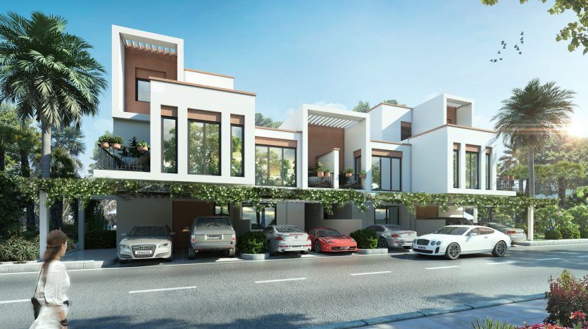Maisons de ville modernes avec toits plats et grandes fenêtres dans les lagons de Damac sur la Costa Brava, avec une rangée de voitures garées et une verdure luxuriante le long de la rue, avec une personne qui passe.