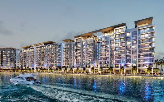 Moderni condomini in riva al mare a Dubai illuminati al tramonto, con uno yacht di lusso che naviga e riflessi vibranti sull'acqua.