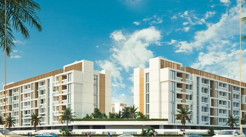 Rendu architectural de grands immeubles résidentiels modernes à plusieurs étages sous un ciel bleu clair, avec des façades blanches avec balcons, entourés de palmiers et une route avec des voitures en mouvement devant, idéal