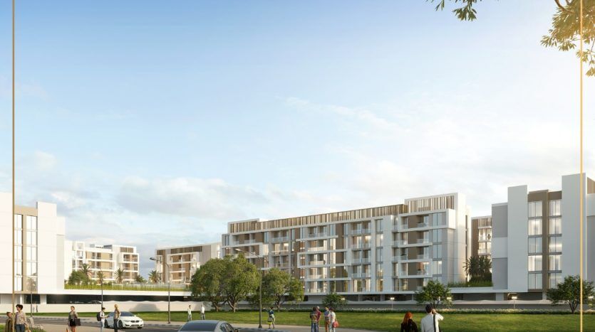 Complexe résidentiel moderne composé de bâtiments blancs dotés de grandes fenêtres, entourés de pelouses vertes et d'arbres. Les gens et les voitures interagissent dans un cadre communautaire dynamique sous un ciel lumineux, caractéristique d'un immeuble recherché.
