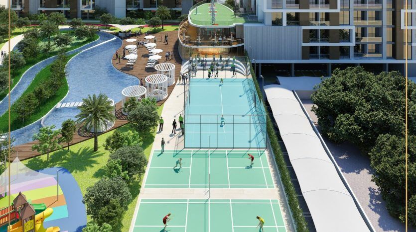 Vue aérienne d'une zone communautaire dynamique comprenant des courts de tennis avec des joueurs, une piscine incurvée en forme de rivière, des jardins paysagers, des sentiers pédestres et des bâtiments résidentiels modernes à Dubaï.