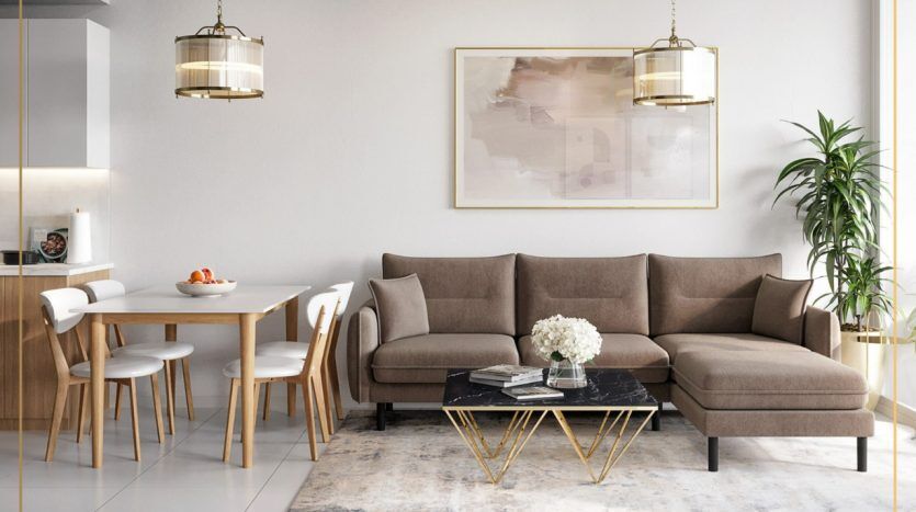 Salon moderne et élégant dans un appartement de Dubaï avec un canapé sectionnel marron, une table basse avec plateau en verre et pieds dorés et un coin repas en arrière-plan, agrémenté de suspensions élégantes et d'un