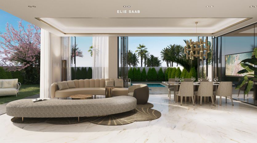 Un espace de vie intérieur luxueux avec un canapé unique de forme ovale, un coin repas et de vastes murs de verre donnant sur un jardin serein avec des palmiers. La villa à Dubaï se caractérise par une architecture moderne et une marque de designer