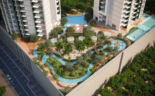 Vista aerea di un complesso residenziale di lusso a Dubai con piscine curve, verde lussureggiante, aree relax e moderni grattacieli in una giornata di sole.
