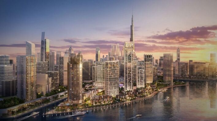 Une vue panoramique sur les toits d'une ville moderne au coucher du soleil, avec des immeubles de grande hauteur le long d'un front de mer à Dubaï, avec des reflets sur l'eau et un ciel spectaculaire.