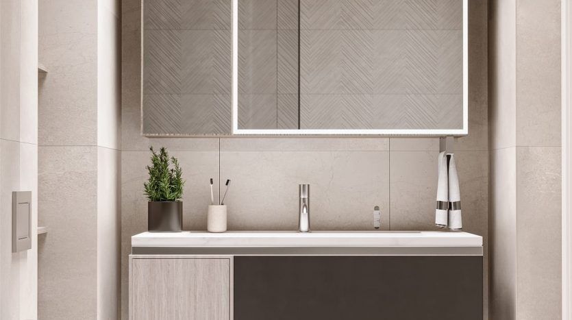 Une salle de bain moderne dotée d'un grand miroir rectangulaire au-dessus d'une vanité gris foncé avec un comptoir blanc, abritant deux lavabos. Il y a une baignoire blanche autoportante et des plantes vertes accentuent l'espace dans ce