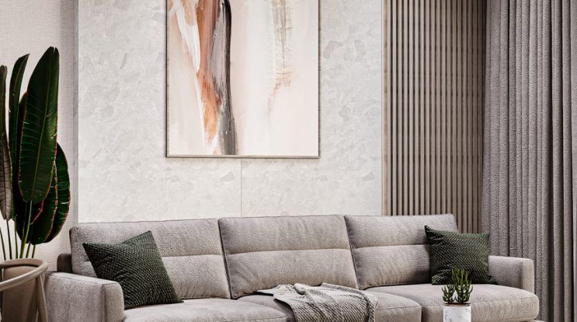 Salon moderne dans un élégant appartement de Dubaï comprenant un grand canapé sectionnel gris, un tapis à motifs et des œuvres d'art abstraites sur un mur texturé, avec des plantes vertes rehaussant la palette de couleurs neutres.