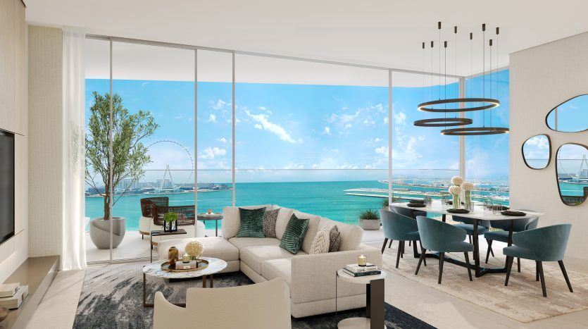 Modern living room in a Dubai apartment with contemporary furnishings overlooking breathtaking ocean views through bay windows, featuring a comfortable sitting area and dining space.