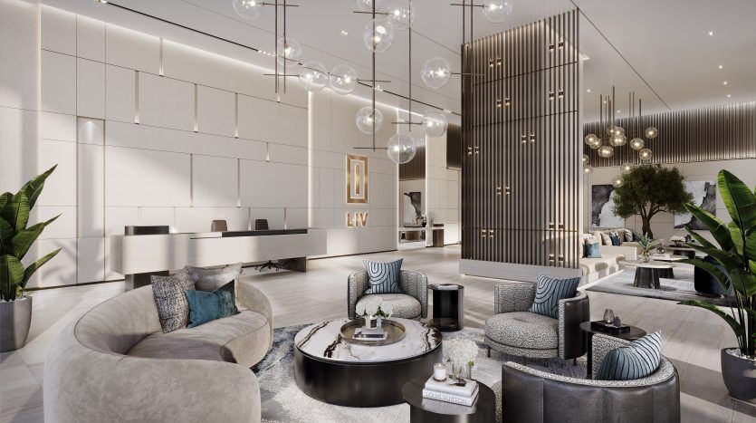 The lobby of a modern, luxury hotel in Dubai features a neutral color palette, elegant furnishings, decorative lighting and lush green plants, providing a spacious, welcoming atmosphere.