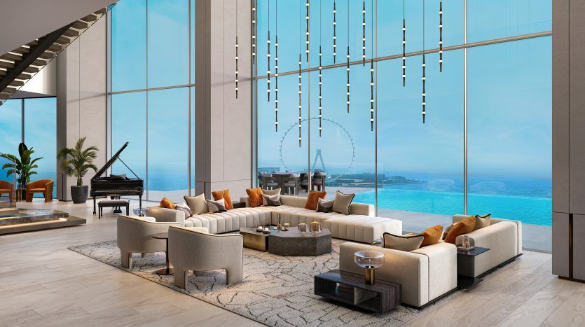 Luxurious living room with modern furnishings and bay windows overlooking panoramic ocean views in Dubai. The room features a piano and elegant hanging lamps.