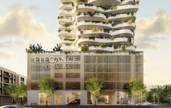 Villa d'architecture moderne labellisée "élégance par chaîma" avec plusieurs niveaux en restanques agrémentés de verdure, et un extérieur éclairé en milieu urbain au crépuscule.