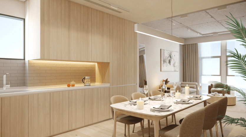 A modern dining room in a Dubai villa featuring a wooden table for four, with white plates and wine glasses. Light wood cabinets and large windows create a bright, welcoming atmosphere.