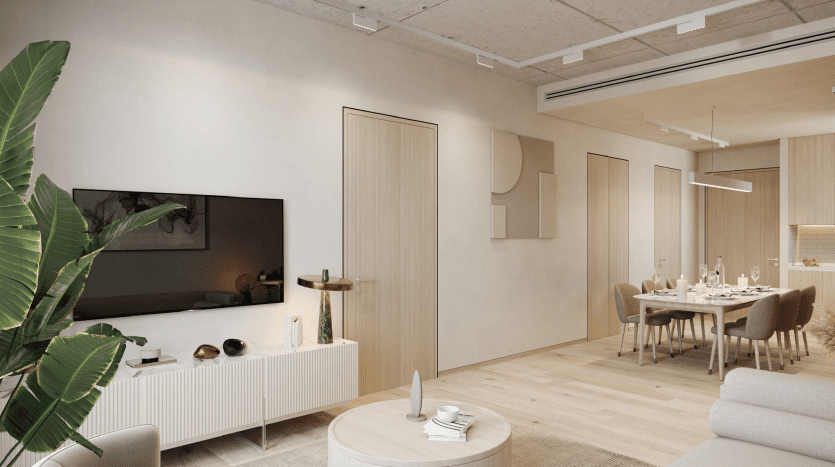 Modern, minimalist living room with dining area in light wood tones, large TV, sofa, white dining set and indoor plants in a Dubai apartment creating a comfortable, seamless space.