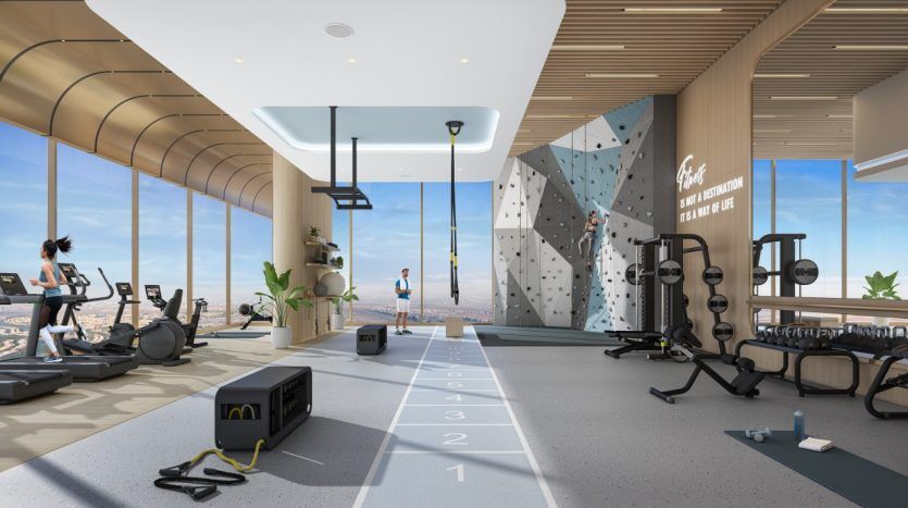 Intérieur de salle de sport moderne avec équipement d'exercice, mur d'escalade et grandes fenêtres donnant sur un paysage urbain. Les gens sont engagés dans diverses activités d'entraînement, y compris des investisseurs de Dubaï discutant d'investissements potentiels.