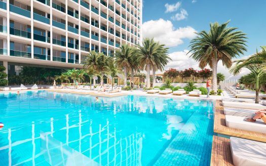 Una lussuosa area piscina in un complesso alberghiero di Dubai, con palme, lettini e un cielo limpido, che rappresenta una destinazione turistica serena e accogliente.