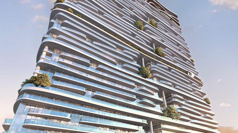 Un immeuble moderne de grande hauteur avec des couches curvilignes, de vastes façades vitrées et de multiples grandes terrasses ornées de verdure sous un ciel bleu, classé par une importante agence immobilière de Dubaï.
