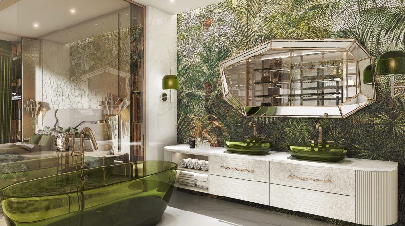 Une salle de bains luxueuse dans une villa de Dubaï comprenant une baignoire en verre vert, une vanité blanche avec des lavabos verts et des murs ornés de papier peint tropical luxuriant. Une armoire à glace ajoute une touche d'élégance.