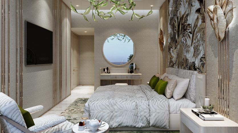 Chambre luxueuse dans une villa de Dubaï comprenant un lit moelleux avec des draps blancs et gris, un miroir rond, des œuvres d'art murales élégantes et un espace détente avec une chaise confortable. La pièce utilise du naturel et