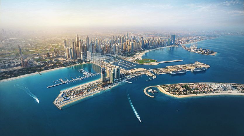 Vue aérienne de la ville moderne de Dubaï avec de grands gratte-ciel près d'un rivage, avec des marinas, des eaux bleu clair et des bateaux. Journée claire et lumineuse avec des vues imprenables.