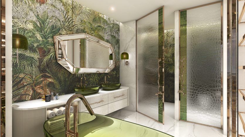 Une salle de bains luxueuse dans une villa à Dubaï avec un papier peint sur le thème tropical, deux vasques en verre au sommet d'une vanité blanche, un miroir octogonal et des portes à panneaux de verre menant à une douche.
