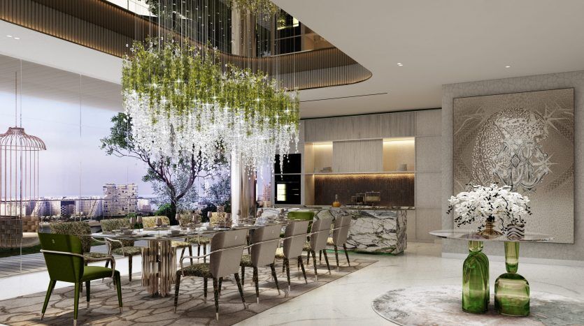 Intérieur de salle à manger luxueux dans un appartement de Dubaï avec une longue table dressée pour un repas, des chaises élégantes, de la verdure suspendue au-dessus, de grandes fenêtres avec vue sur la ville et une décoration murale artistique.