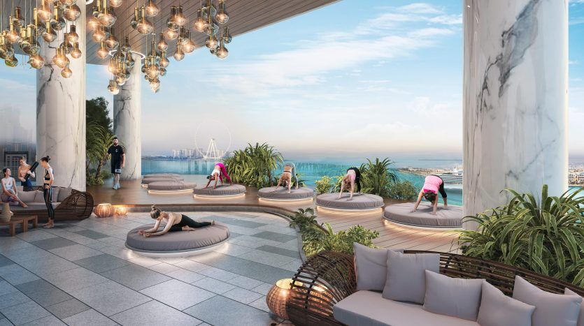 Salon luxueux sur le toit de Dubaï avec des gens se relaxant sur des lits et des canapés circulaires, profitant d'une vue panoramique sur la mer sous une pergola avec des lampes suspendues.