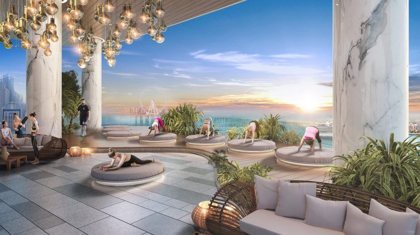 Salon luxueux sur le toit avec des groupes de personnes se détendant et discutant, doté de sièges moelleux, de plantes exotiques, de lampes suspendues et d'une vue panoramique sur les toits de Dubaï au coucher du soleil.