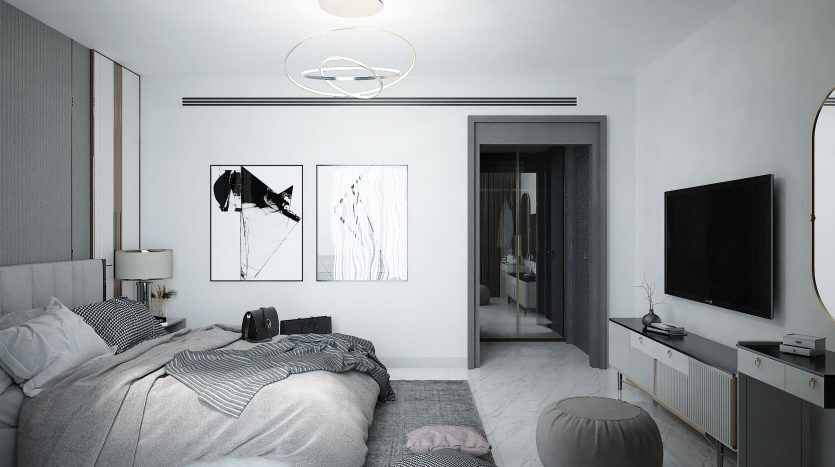 Une chambre moderne et monochrome dans un appartement de Dubaï comprenant un lit soigneusement fait avec des couvertures à rayures, des œuvres d'art murales abstraites, un plafonnier circulaire et un meuble TV élégant. Une porte ouverte montre un aperçu