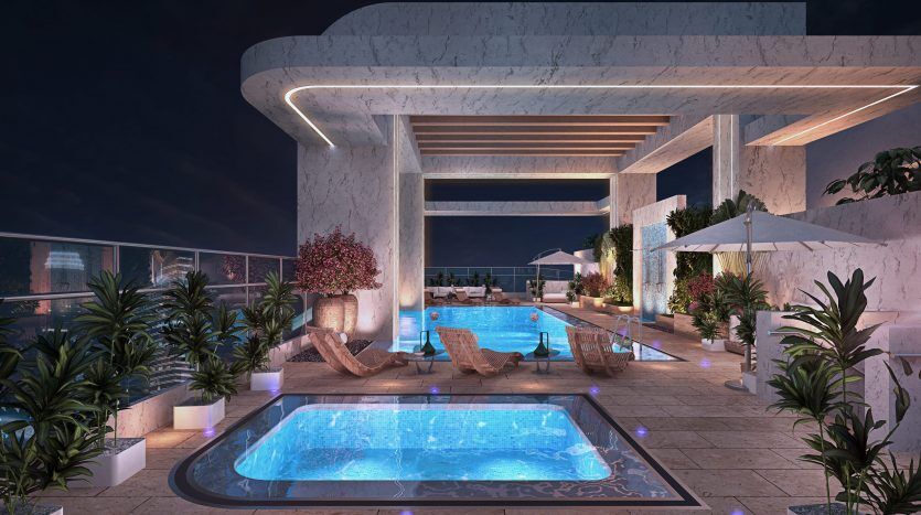 Un luxueux espace piscine sur le toit la nuit, doté d'un jacuzzi éclairé, d'une piscine et entouré d'une verdure luxuriante et d'une architecture moderne, parfait pour un investissement à Dubaï.