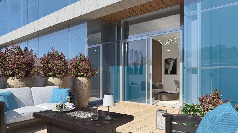 Balcon moderne avec balustrades en verre, plantes luxuriantes, canapé et fauteuils confortables, petite table avec un livre et vue sur l'intérieur élégant d'un appartement de Dubaï. Lumière du soleil éblouissante