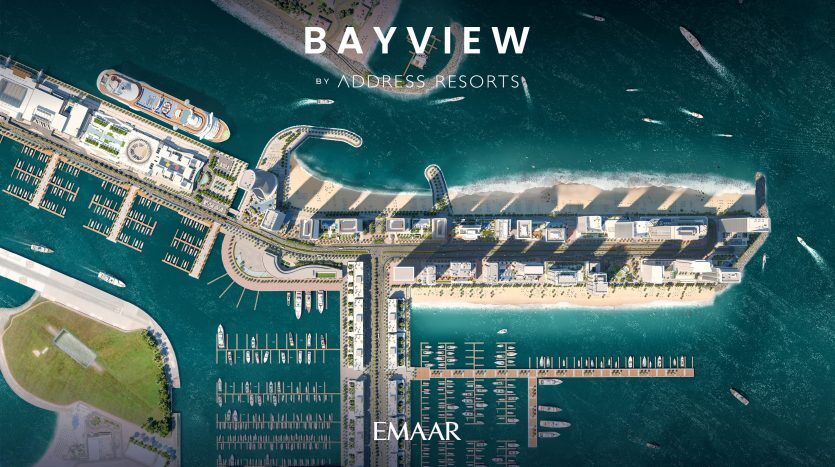Vue aérienne de Bayview by Andrees Resorts, montrant la marina avec des bateaux, des quais et des bâtiments hôteliers entourés d'eau bleu clair, avec le nom « Emaar » visible au