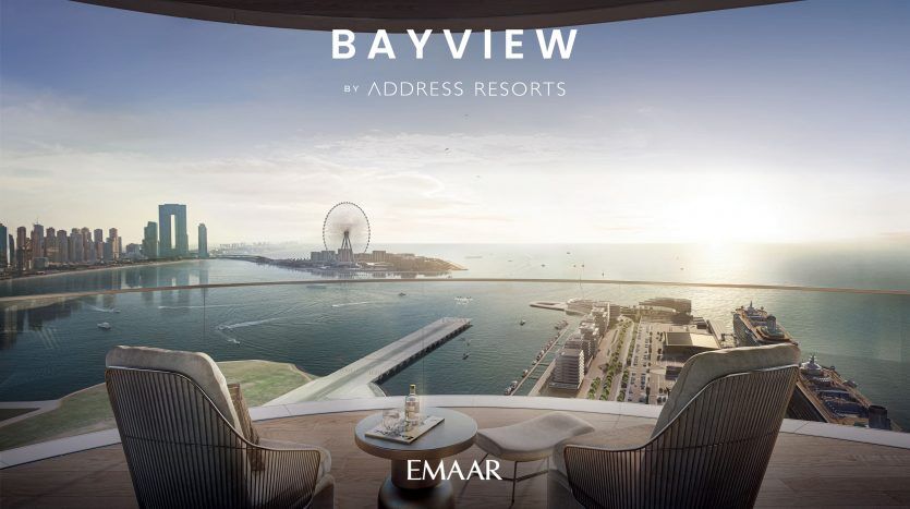 Vue depuis le balcon d'un appartement en hauteur donnant sur une marina, les toits de la ville et la grande roue au lever du soleil, avec deux chaises et une table avec du café. Texte promotionnel « Bayview par