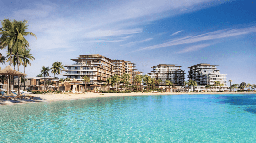 Lujoso complejo en primera línea de playa con varios edificios modernos rodeados de palmeras, con vistas a una gran piscina de color turquesa bajo un cielo azul despejado, que representa una oportunidad inmobiliaria de primer orden en Dubai.