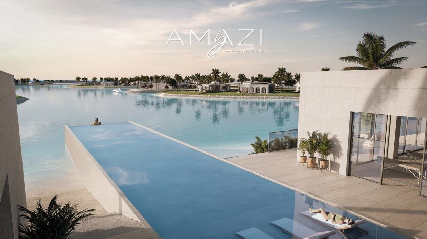 Vue luxueuse sur le complexe avec une piscine à débordement donnant sur un plus grand plan d'eau, des palmiers et des villas modernes sous un ciel dégagé. Le logo « amazi » est affiché bien en évidence dans le cadre d'un