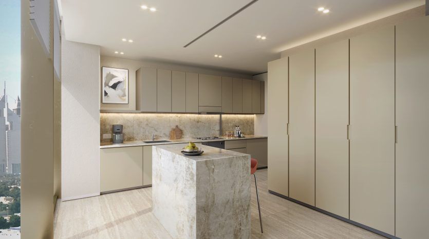 Une cuisine moderne avec des armoires élégantes, un îlot en marbre et des appareils électroménagers intégrés. Les tons neutres et l'éclairage lumineux créent un espace élégant dans cette villa de Dubaï.
