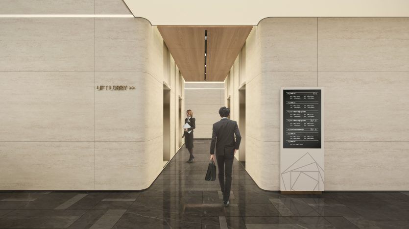 Un homme en costume se dirige vers une femme dans le couloir d’un immeuble de bureaux moderne à Dubaï, en passant devant un panneau d’annuaire. L'intérieur présente des murs en pierre simples et élégants et un éclairage chaleureux.