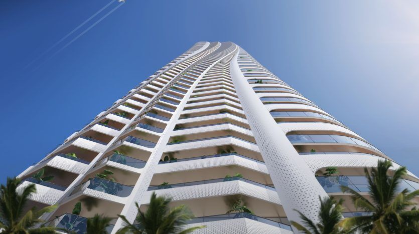 An imposing modern white skyscraper with curvilinear balconies stretches towards a clear blue sky, with palm trees in the foreground and a trail of jets above, embodying Dubai's premier real estate.