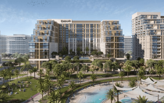Veduta aerea di un moderno complesso urbano caratterizzato da grattacieli con il logo "emaar", circondato da un verde lussureggiante, palme e persone che si godono una giornata di sole con una grande piscina