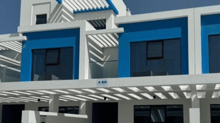 Modern architectural facade featuring a building with clean lines, bold blue accents and gray and white colors, displaying a patterned shadow structure in an Investissement Dubaï project.