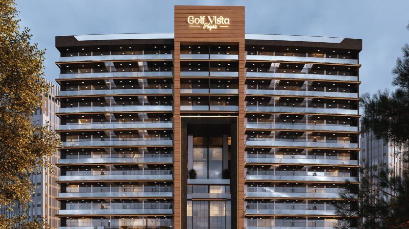 Vue extérieure du bâtiment moderne Golf Vista au crépuscule, avec des balcons éclairés et une plaque signalétique bien visible au sommet, ce qui en fait un investissement idéal à Dubaï.