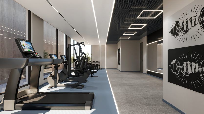 Un intérieur de salle de sport moderne comprenant des tapis roulants avec écrans numériques, des appareils de musculation et des supports d'haltères, accentué par des sols élégants et réfléchissants et un éclairage innovant dans une villa à Dubaï.