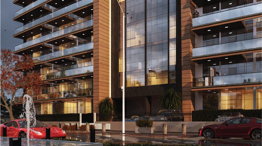 Immeubles de bureaux modernes aux façades en verre réfléchissantes au crépuscule à Dubaï, avec une fontaine et une voiture de sport rouge garée au premier plan.