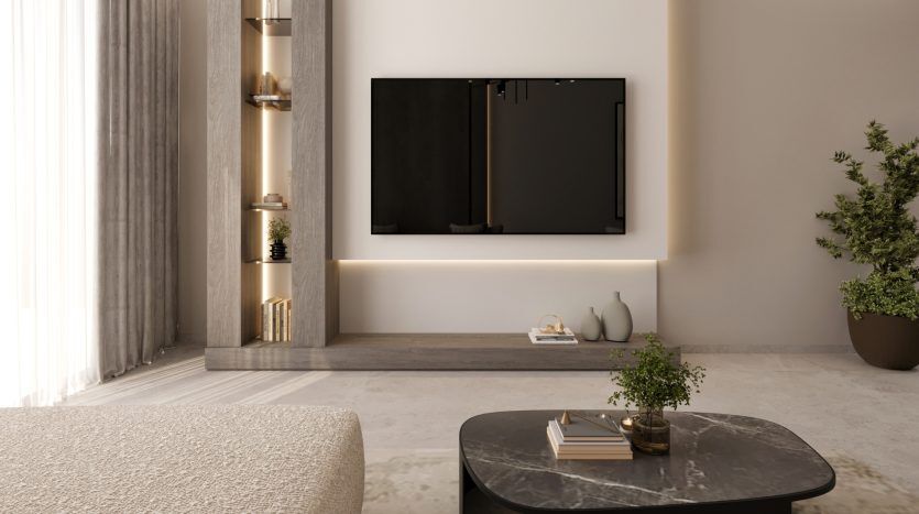 Un salon moderne dans un appartement de Dubaï comprenant une élégante télévision murale au-dessus d'une console basse, accentuée par un éclairage ambiant et une décoration minimaliste, avec une table basse en marbre et un canapé confortable