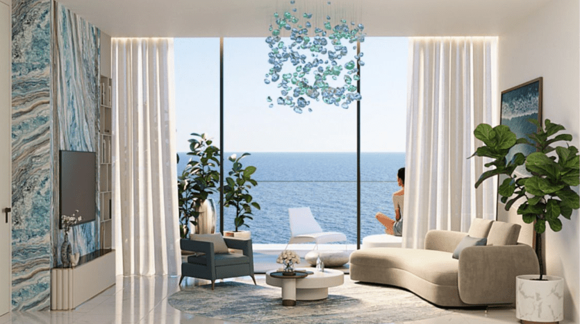 Un salon moderne dans un appartement de Dubaï avec une vue panoramique sur l'océan, doté d'un canapé beige, de chaises, de plantes et d'un décor artistique bleu, avec une femme se relaxant près de la fenêtre.