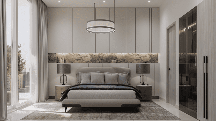 Intérieur de chambre moderne dans un appartement de Dubaï comprenant un grand lit avec une literie bleue et grise, flanqué de deux tables de nuit et lampes symétriques, une tête de lit en panneaux de bois et un plafonnier circulaire.