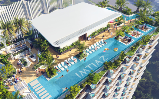 Vista aerea di una lussuosa piscina sul tetto di un grattacielo a Dubai, circondata da piante tropicali, con persone che prendono il sole e nuotano.