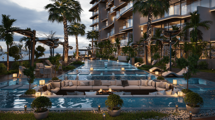 Piscine luxueuse au crépuscule avec torches allumées et palmiers, entourée d'un bâtiment moderne à Dubaï. Des chaises longues et des cabanes au bord de l'eau scintillante ajoutent à l'ambiance relaxante.