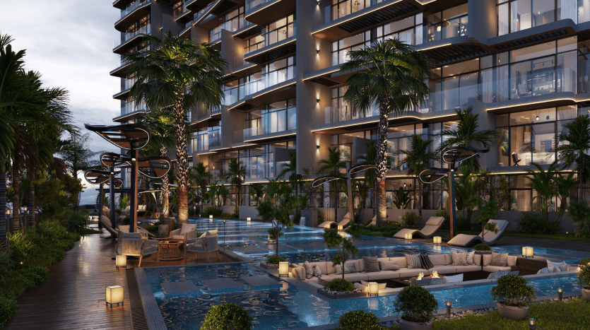 Piscine luxueuse du complexe au crépuscule avec jeux d'eau illuminés, entourée d'immeubles d'appartements modernes de Dubaï, de plantes tropicales et de mobilier d'extérieur élégant.